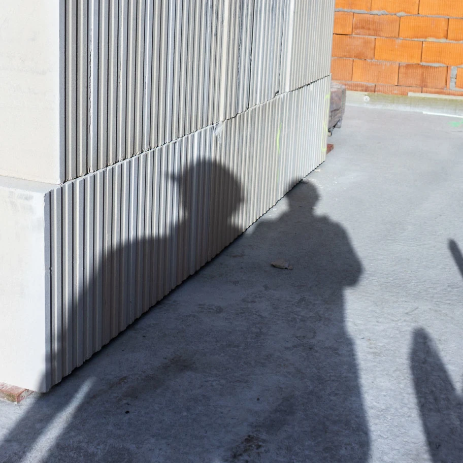 Die Schatten von zwei Personen fallen auf Baumaterial